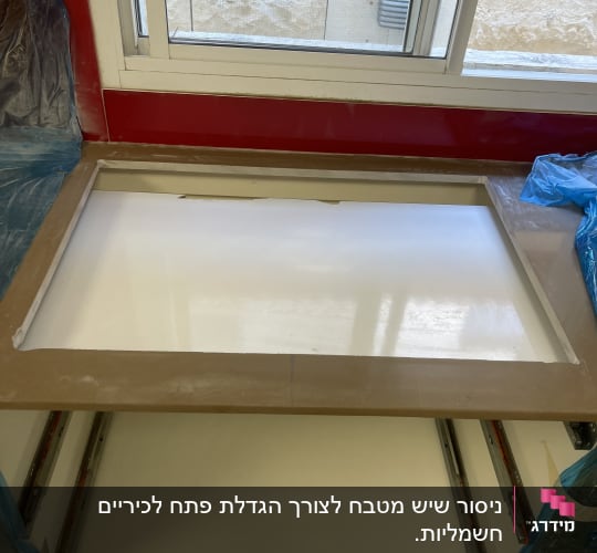 משטח שיש ליד חלון עם כיסוי פלסטיק כחול